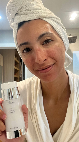 Allure contributing commerce editor Deanna Pai applying SkinMedica's TNS Advanced Serum
