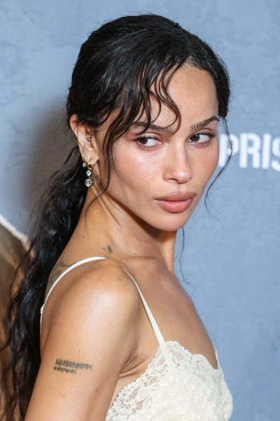 Zoë Kravitz posing in a cream colored slip dress